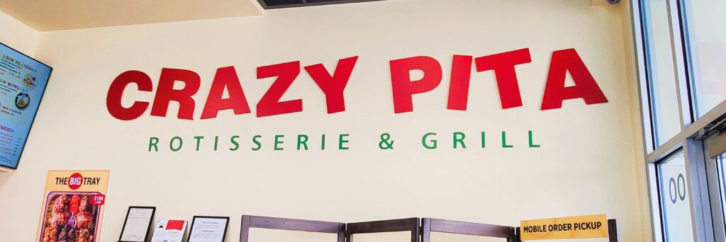 The Crazy Pita Rotisserie & Grill sign at the entrance of the Downtown Summerlin location